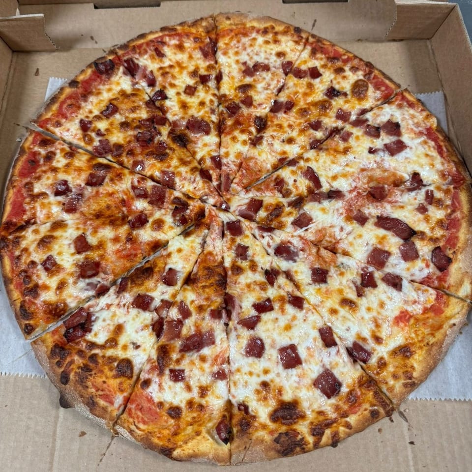 A Falcon Pizza pepperoni pizza, cut into many slices, in a cardboard delivery box.